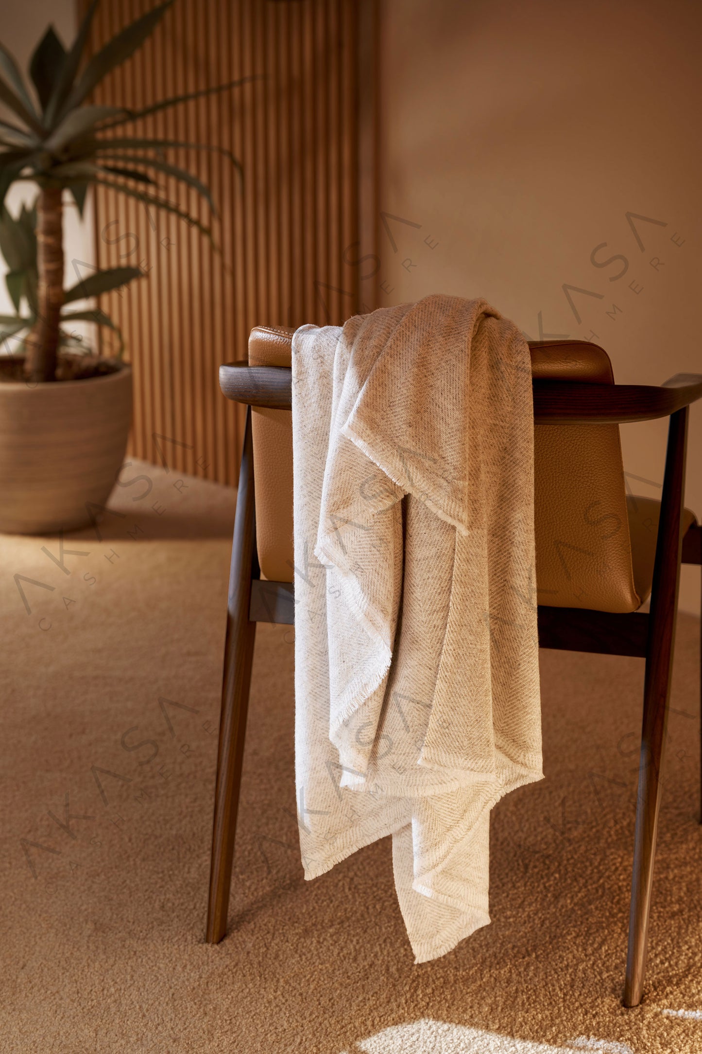 Luxury cashmere blanket styled on a sofa in a modern living room interior